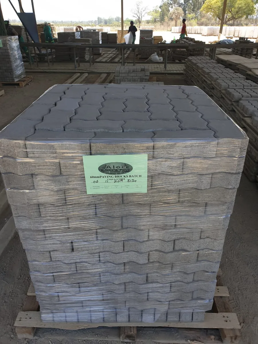 Pallet of grey cement paving blocks delivered to an industrial site ready to lay